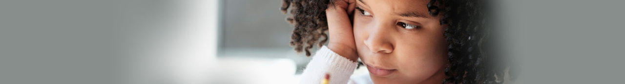 Girl in classroom holding a pencil